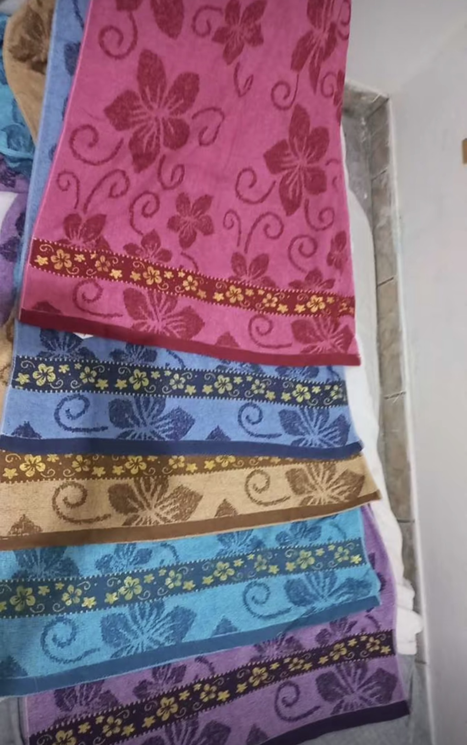 Toalhas Belora estampadas penduradas em rosa, azul, bege, turquesa e roxo