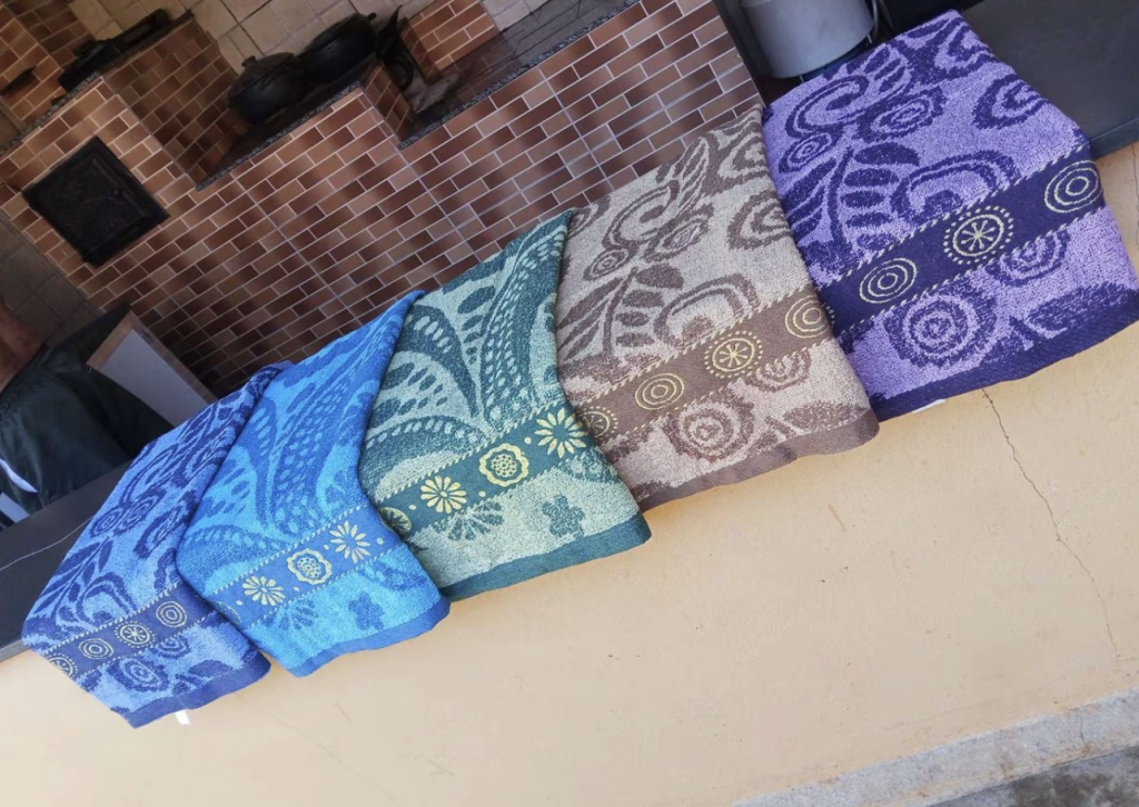 Toalhas Belora estendidas do lado de fora em tons de azul, verde-água, bege e roxo